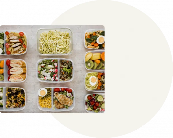 Tupperwares with meal prepped food is standing in lines next to one another on a table, with the image being in the foreground of a grey background with a white circle in the middle.