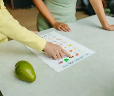 Woman pointinig finger to nutrition table printed on paper