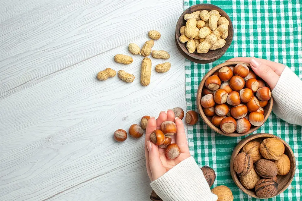 Top view of fresh raw hazelnuts with peanuts and walnuts.