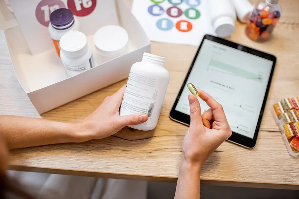 A person analyzing the information on a dietary supplement container.