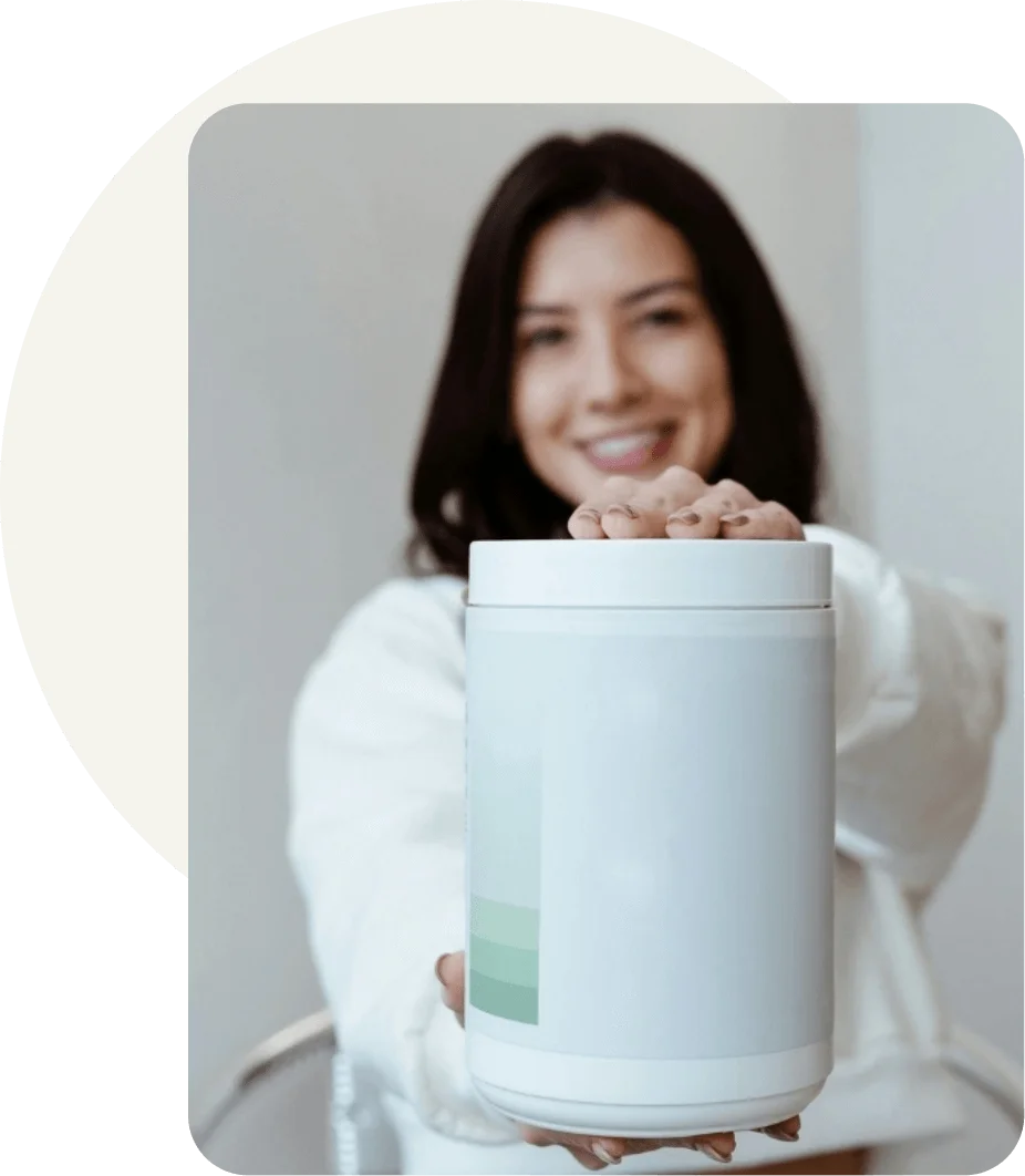 Person presenting a white supplement canister with minimal product label toward the camera